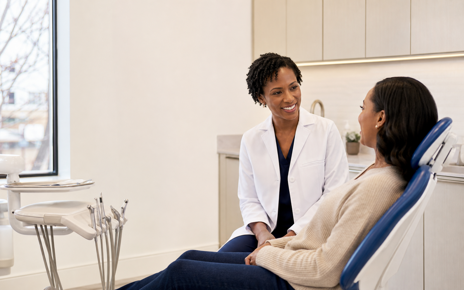 Dentist speaking warmly with a patient in a modern treatment room